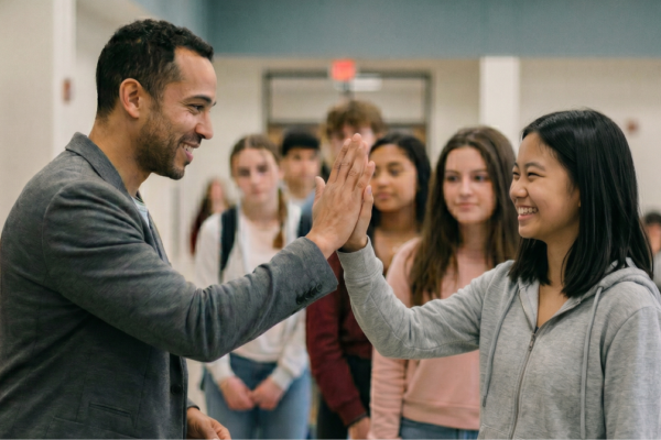 A teacher and student giving each other a high five