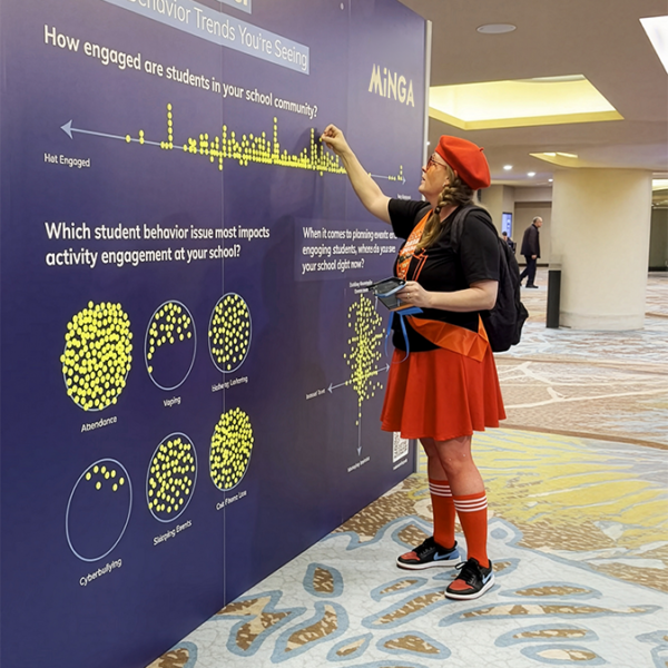 An educator engages with Minga's Engagement Wall at the CADA 2026 state convention, sharing views on student behavior trends.