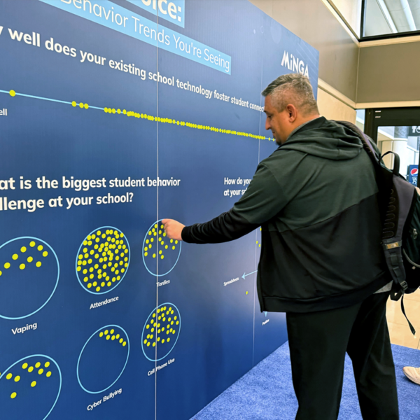 An educator adds his response to Minga's Engagement Wall at FETC 2026 in Orlando.