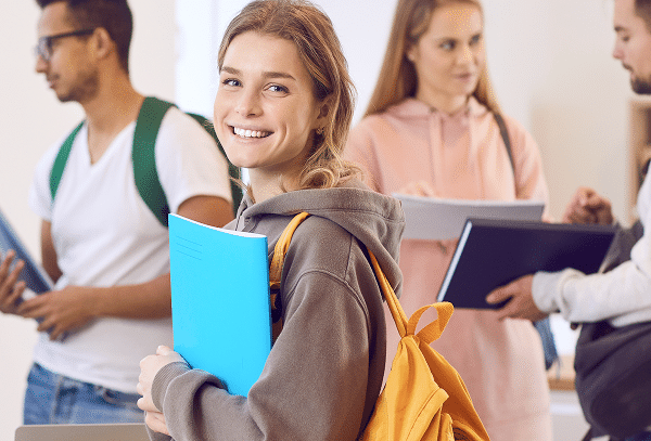 High school student walking through a school hallway with classmates